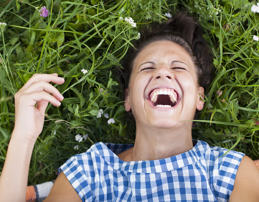 A woman laughing outdoors